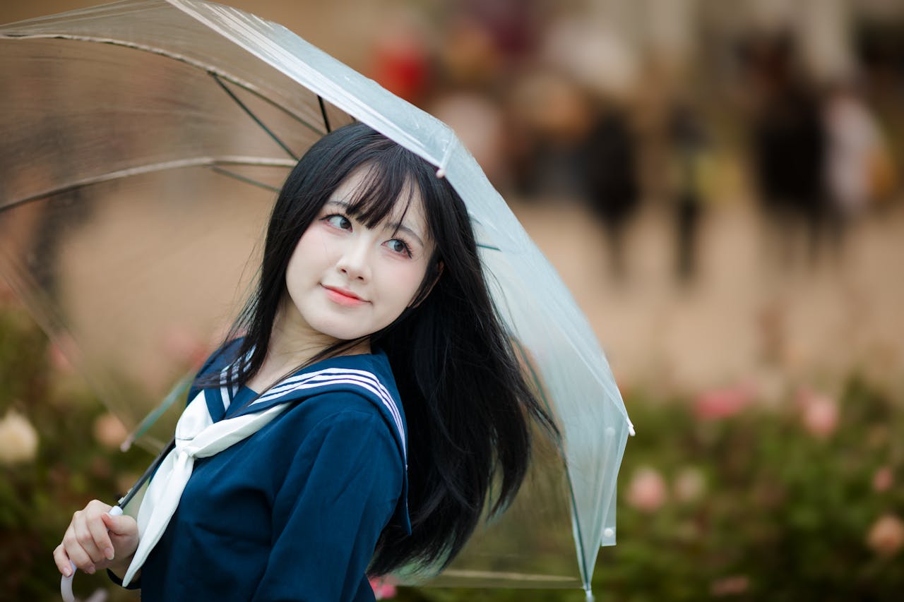 Smiling woman in sailor uniform with umbrella in garden. Perfect for stock images.